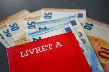 Livret A rouge posé sur des billets en euros, symbole d’épargne en France